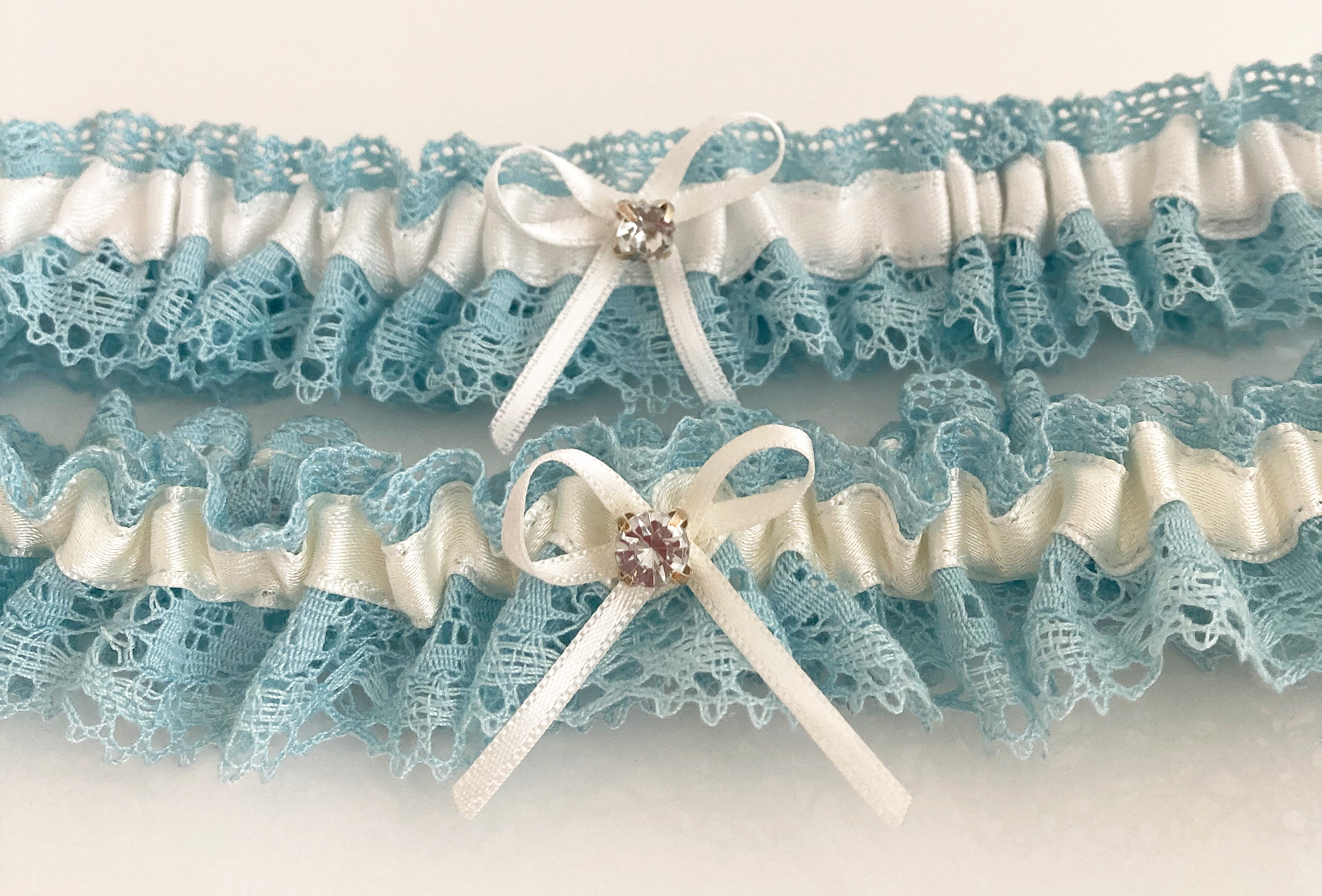 blauwe kousenbanden voor de bruid in ivoor en offwhite